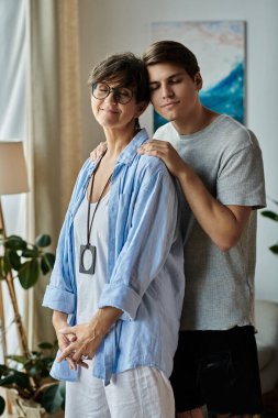 Bir anne ve yetişkin oğlu, eve davet edilirken birbirlerine eşlik ederek hassas bir anı paylaşıyorlar..