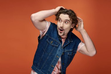 Bir adam duygularını parlak, renkli bir fon önünde sergiliyor..