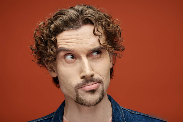 Поразительный человек с вьющимися волосами передает глубокие эмоции в яркой обстановке.
