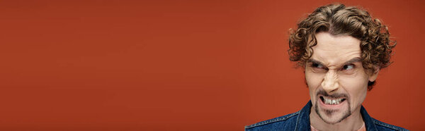 Красивый мужчина демонстрирует глубокие эмоции в яркой обстановке.