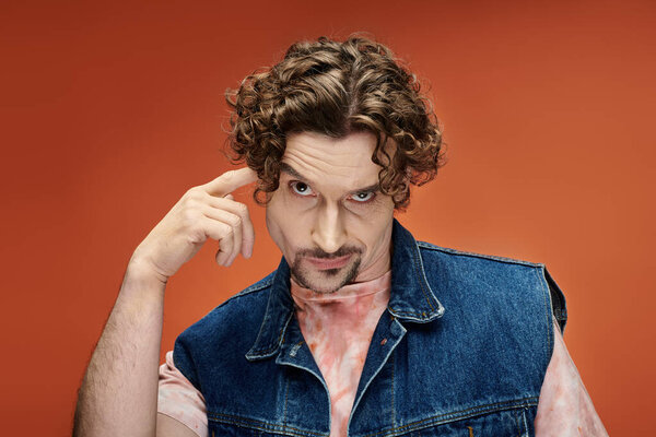 Человек с вьющимися волосами передает глубокие эмоции в красочной обстановке.