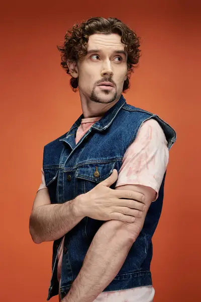 stock image A handsome man expresses emotion in front of a bold orange background.