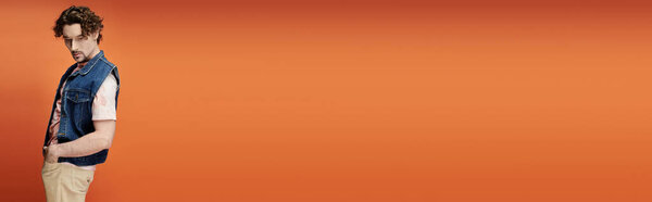 Стильный мужчина уверенно стоит, демонстрируя свою эмоциональную глубину среди ярких красок.