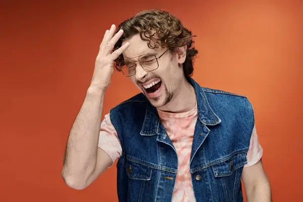 stock image A man joyfully poses with flair, radiating emotion against a bright backdrop.