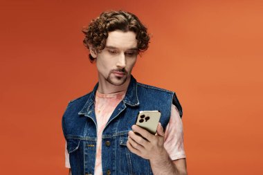 Yakışıklı bir adam canlı bir şekilde telefonuna dikkatle bakar..