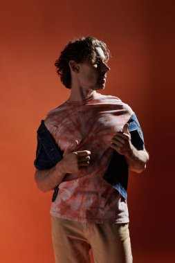 Yakışıklı bir adam dramatik bir şekilde poz verirken derin duygular ifade eder..