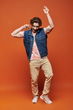 Şık bir adam renkli bir ortamda enerjik bir enerjiyle dans eder..