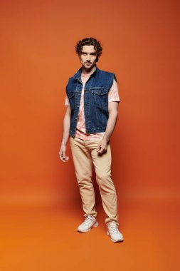 Şık bir adam canlı bir arkaplanda dururken duygularını ifade eder..