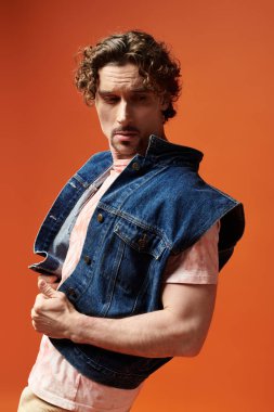 Bir adam kendine güvenen bir poz verir, duygularını canlı bir arka plana karşı sergiler..