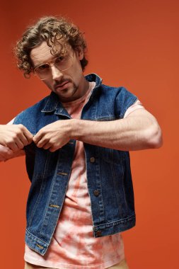 Kıvırcık saçlı bir adam neşeli bir ortamda tarzını sergiliyor..