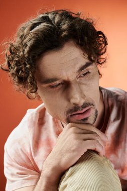 Düşünceli bir adam canlı ve renkli bir arka planda duygularıyla poz verir..