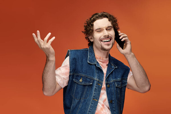 Веселый человек радостно разговаривает по телефону на фоне яркого фона.