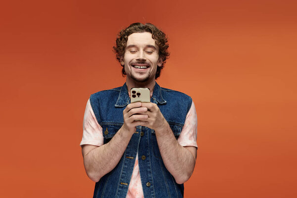 Веселый человек очаровывает своей улыбкой во время использования смартфона.
