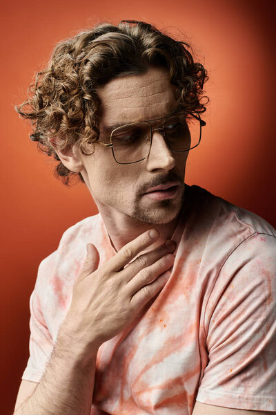 Красивый мужчина с вьющимися волосами выражает эмоции на ярком фоне.