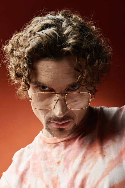 Поразительный человек демонстрирует свои глубокие эмоции перед красочным фоном.