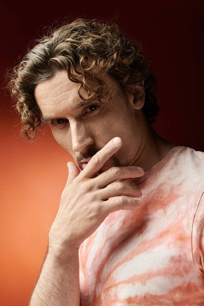 Красивый мужчина выражает глубокие эмоции в яркой и красочной обстановке.