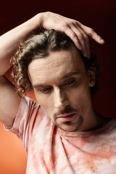 Красивый мужчина выражает глубокие эмоции на ярком фоне.