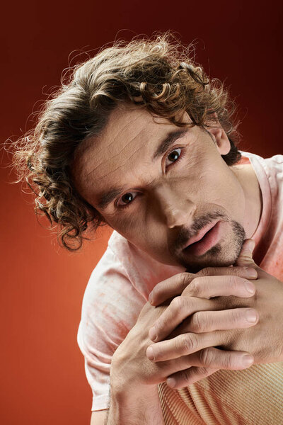 Красивый мужчина демонстрирует глубокие эмоции, позируя с сжатыми руками..