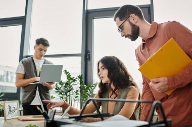 Three coworkers collaborate thoughtfully at their workplace. clipart