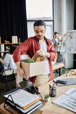 İş arkadaşları zor bir işten çıkarma anında ofis ortamında eşyalarını paketlerler.
