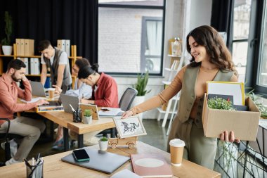 Woman packing belongings during a layoff, colleagues on backdrop. clipart