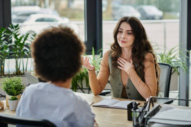 Profesyoneller şık bir iş yerinde iş geçişleri hakkında sohbet ederler..