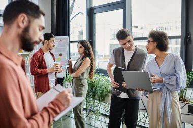Profesyoneller iş yerinde zorlu değişiklikleri incelerken görüşleri tartışıp paylaşıyorlar.