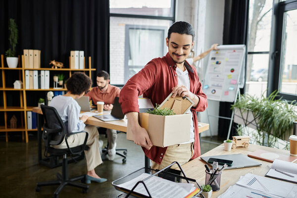 Colleagues gather in a bright workspace, one is packing belongings amid transitions.