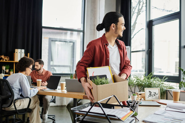 Team members working while one packing items while managing workplace transitions.