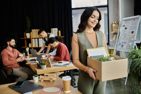 Professional prepare for change while packing personal belongings in the office, colleagues on backdrop.