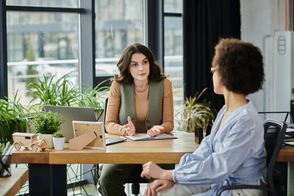 stock image Colleagues engage in a serious discussion amidst a layoff process.