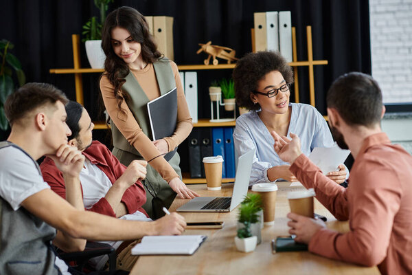 Группа коллег обсуждает процесс работы в непринужденной обстановке офиса.