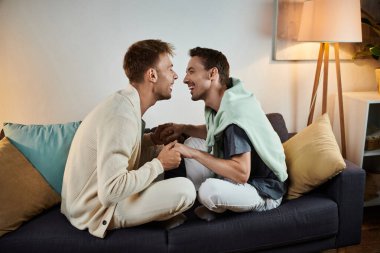 İki erkek rahat kanepelerinde kucaklaşırken keyifli bir anı paylaşıyor..