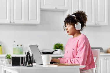 İşine dalmış, kulaklık takmış ve evinde dinlenen genç bir kadın..