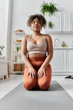 Genç bir kadın rahat yaşam alanında huzur içinde meditasyon yapıyor..
