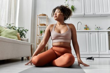 Genç bir kadın evine davet ederken huzurlu bir yoga seansının keyfini çıkarıyor..
