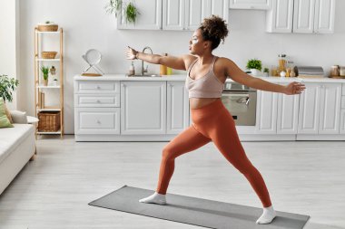 Güzel bir kadın, içi parlak bir iç mekanla çevrili yoga antrenmanına çıkıyor..