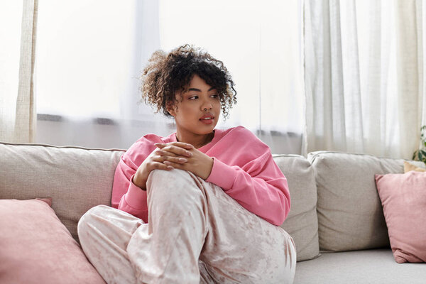 Молодая женщина наслаждается своим спокойным моментом на удобном диване.