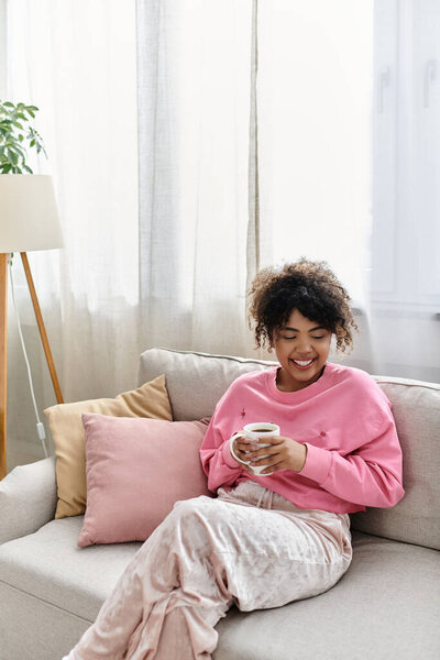 Молодая женщина наслаждается успокаивающим моментом дома со своим любимым напитком.