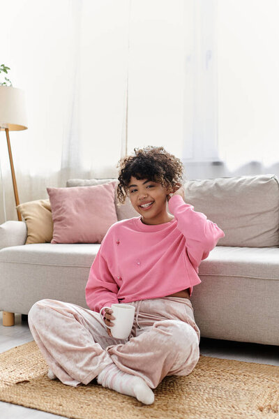 Молодая женщина наслаждается мирным моментом, потягивая теплый напиток дома.