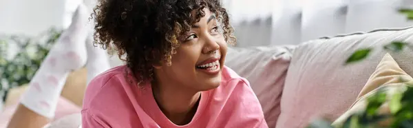 stock image A young woman enjoys a joyful moment while relaxing indoors at home.