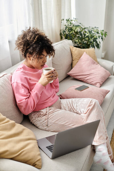 A relaxed moment at home with a warm drink and laptop in a tranquil setting.