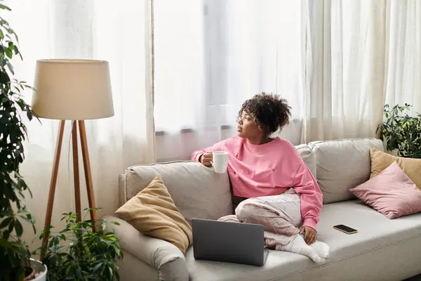 stock image She enjoys a peaceful moment at home, sipping her drink and contemplating.