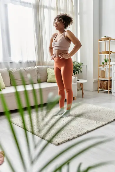 stock image A joyful young woman expresses happiness while at home in her living room.