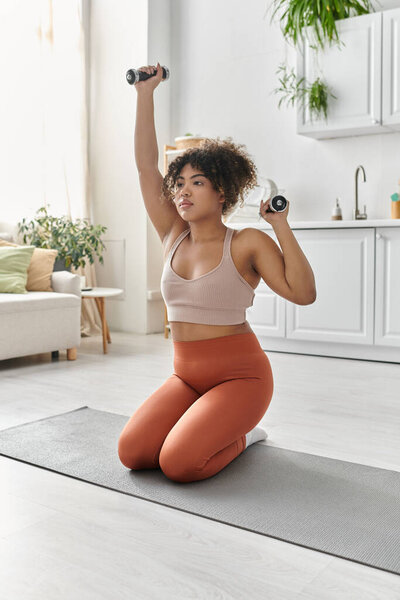 Woman engaged in a fitness routine while kneeling on a mat at home.