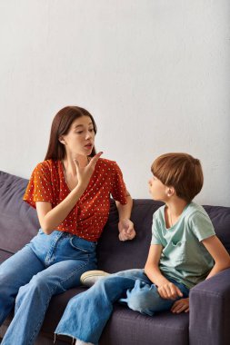 Bir anne işaret dili kullanarak işitme engelli oğluyla meşgul olur..