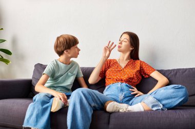 Bir anne, işitme engelli oğluyla samimi bir ortamda işaret dili kullanarak meşgul olur..