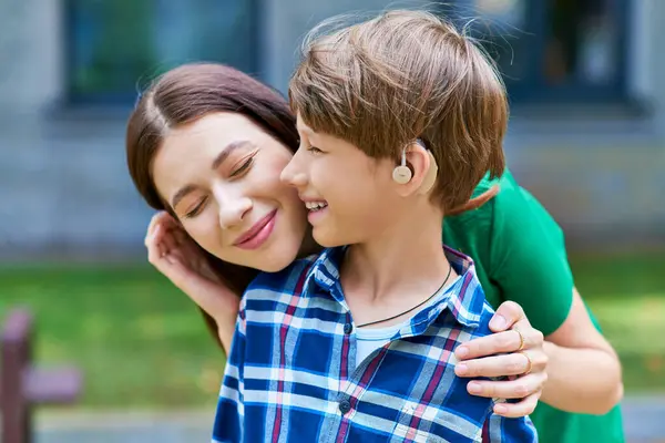 stock image A mother embraces her hearing impaired son, radiating warmth and connection.