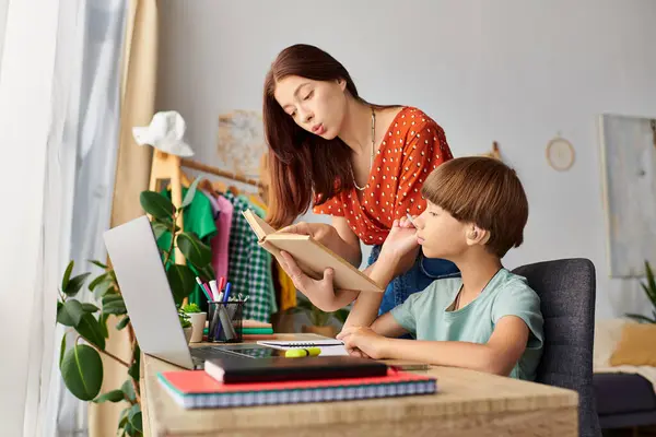 stock image A lovely mother assists her hearing impaired son with a book at home.