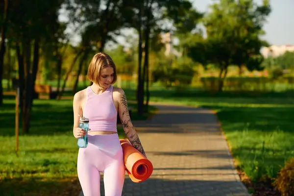 stock image She walks confidently through the park, preparing for her yoga session.